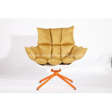 white husk chair with orange seat cushion